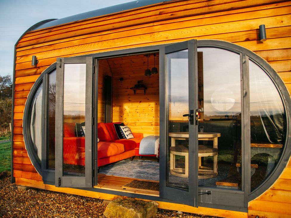 A living room with a couch and table at The Palm in Truro