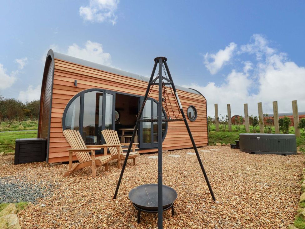 A cabin with deck chairs and a hot tub at The Palm in Truro