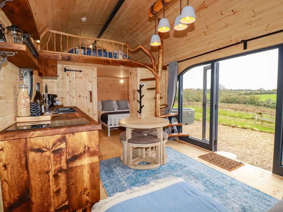 A living room with a kitchen area and a sofa at The Palm in Truro