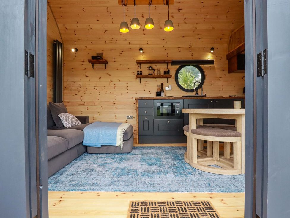 A living room with a sofa and dining area at The Palm in Truro