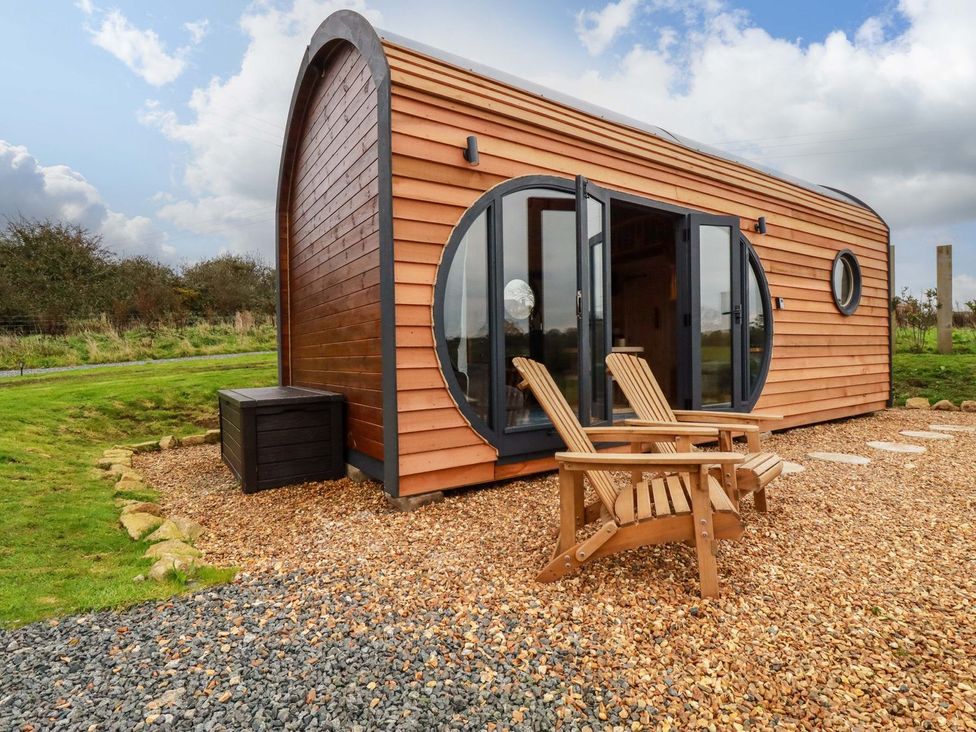 A wooden cabin with chairs in the garden at The Palm in Truro