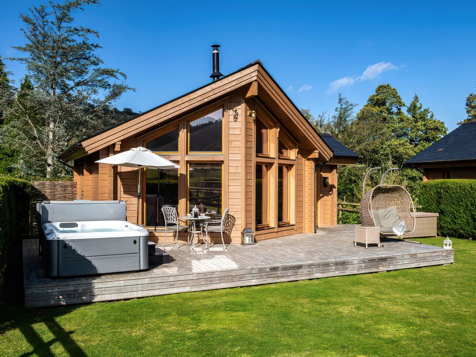 A terrace with a hot tub and seating at Gezellig Log Cabin in Llandrillo