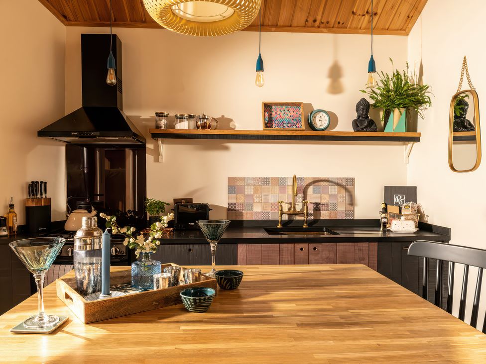 A kitchen with a sink and stove at Gezellig Log Cabin in Llandrillo