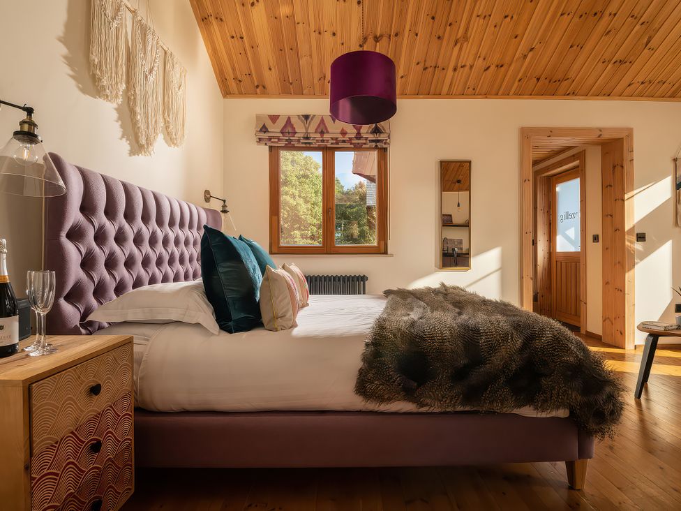 A bedroom with a bed and window at Gezellig Log Cabin in Llandrillo