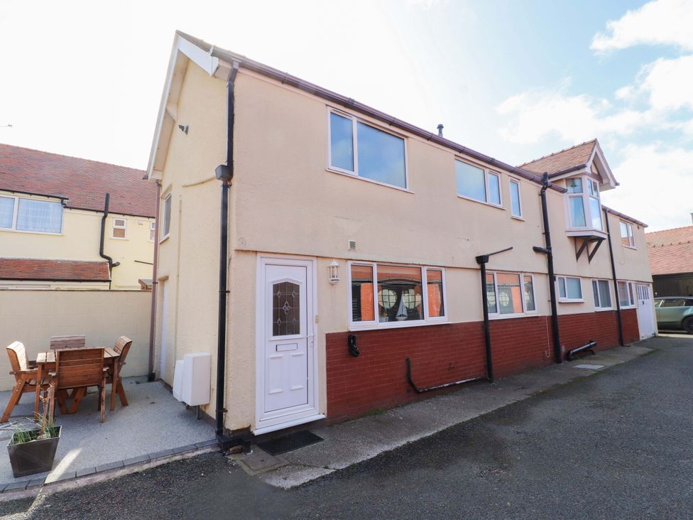 An outdoor area with a building and dining table at The Old Stables in Rhos-On-Sea