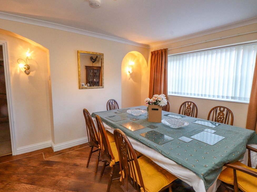 A dining room with a table set for meals at The Old Stables in Rhos-On-Sea