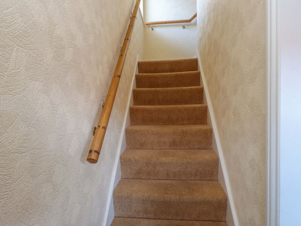 Stairs with a handrail in a staircase at The Old Stables in Rhos-On-Sea