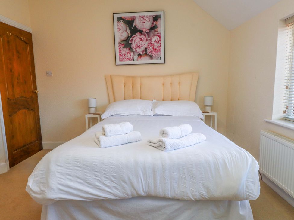 A bedroom with a bed and towels on top at The Old Stables in Rhos-On-Sea
