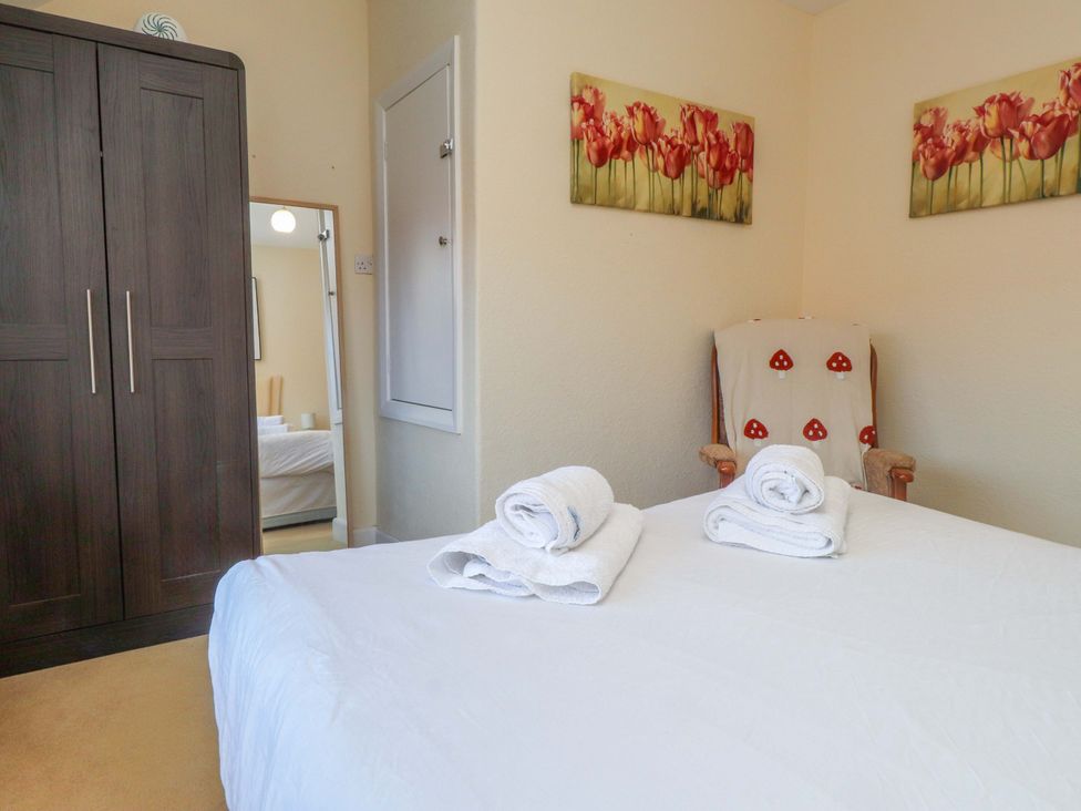 A bedroom with a bed and wardrobe at The Old Stables Rhos-On-Sea