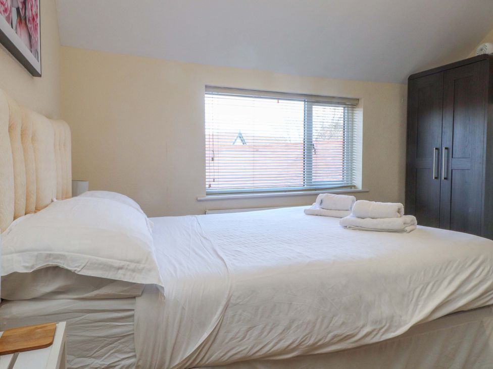 A bedroom with a double bed and a wardrobe at The Old Stables in Rhos-On-Sea