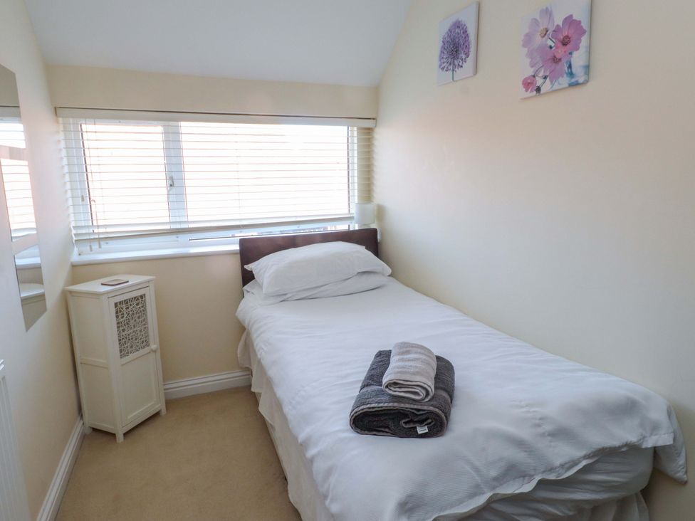 A bedroom with a single bed and bedside table at The Old Stables in Rhos-On-Sea