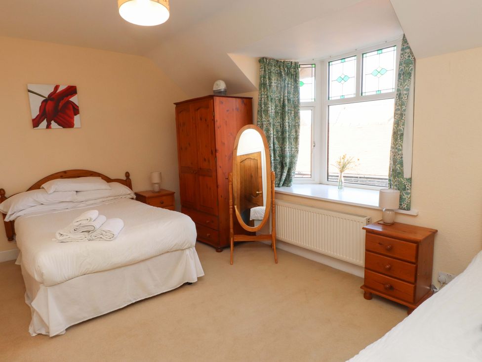 A bedroom with a bed and an armoire at The Old Stables in Rhos-On-Sea