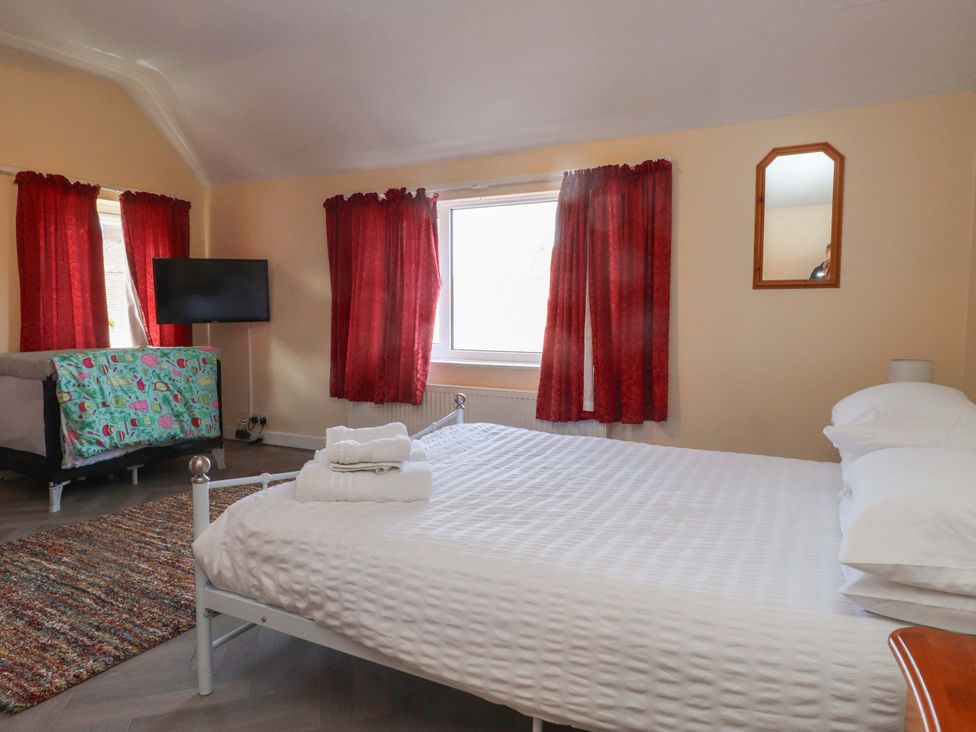 A bedroom with a bed and television at The Old Stables in Rhos-On-Sea