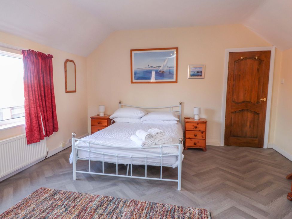 A bedroom with a bed and bedside tables at The Old Stables in Rhos-On-Sea