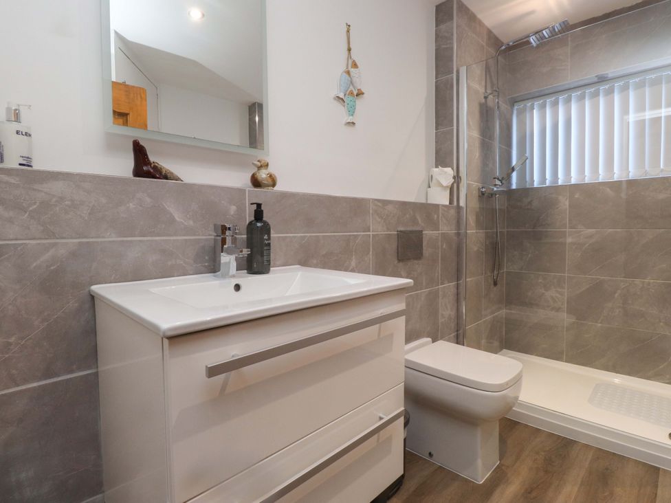 A bathroom with a sink, toilet, and shower at The Old Stables in Rhos-On-Sea