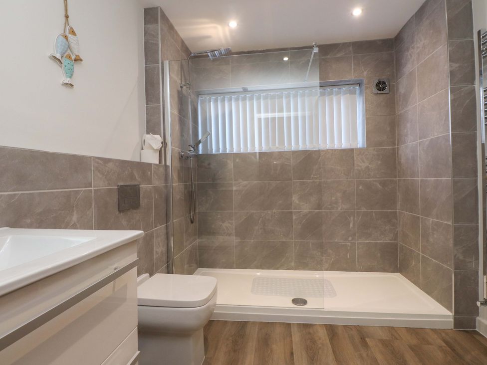 A bathroom with a shower and toilet at The Old Stables in Rhos-On-Sea