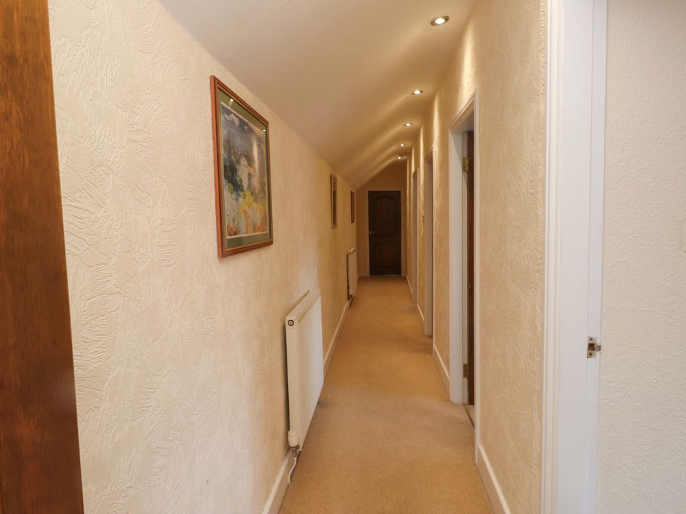A hallway with a radiator and wall art at The Old Stables in Rhos-On-Sea