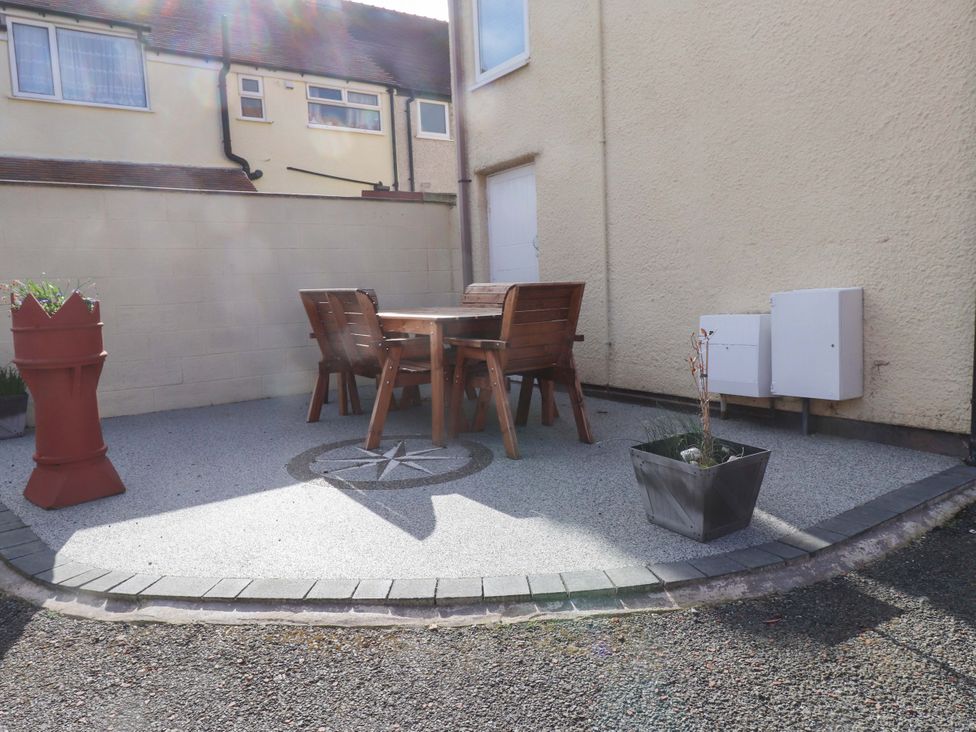 An outdoor area with a table and chairs at The Old Stables in Rhos-On-Sea