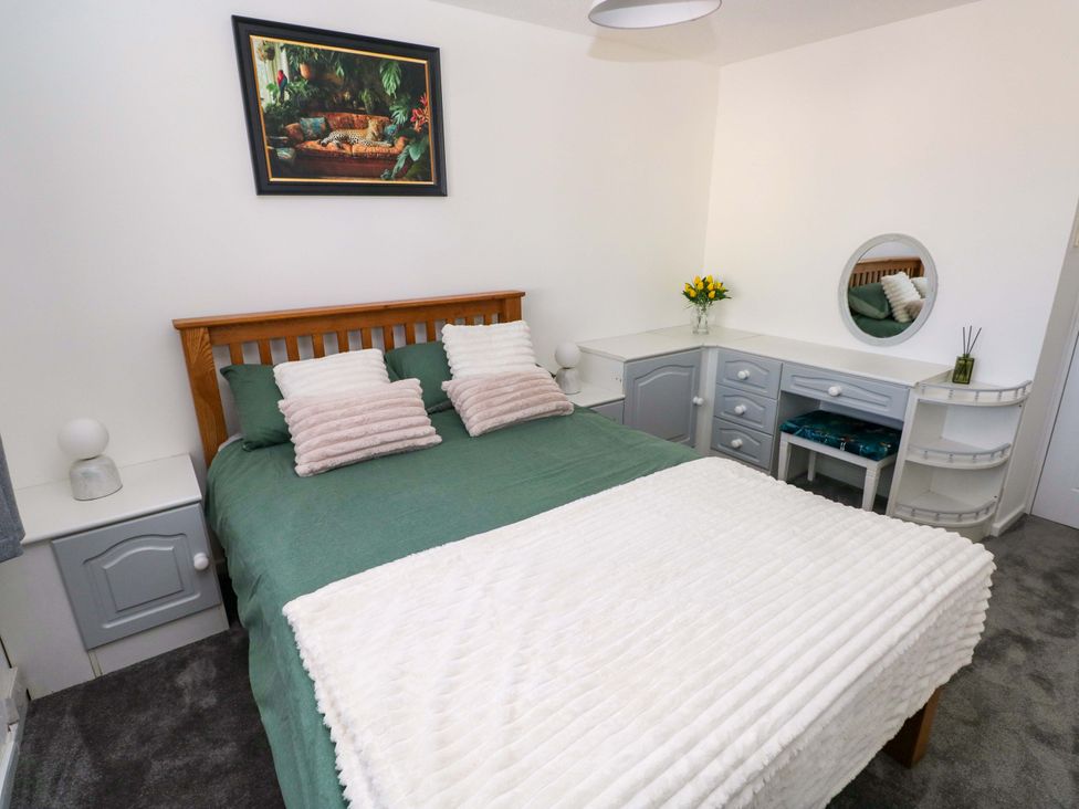 A bedroom with a bed and dresser at The Gower Gateway in Gowerton near Swansea
