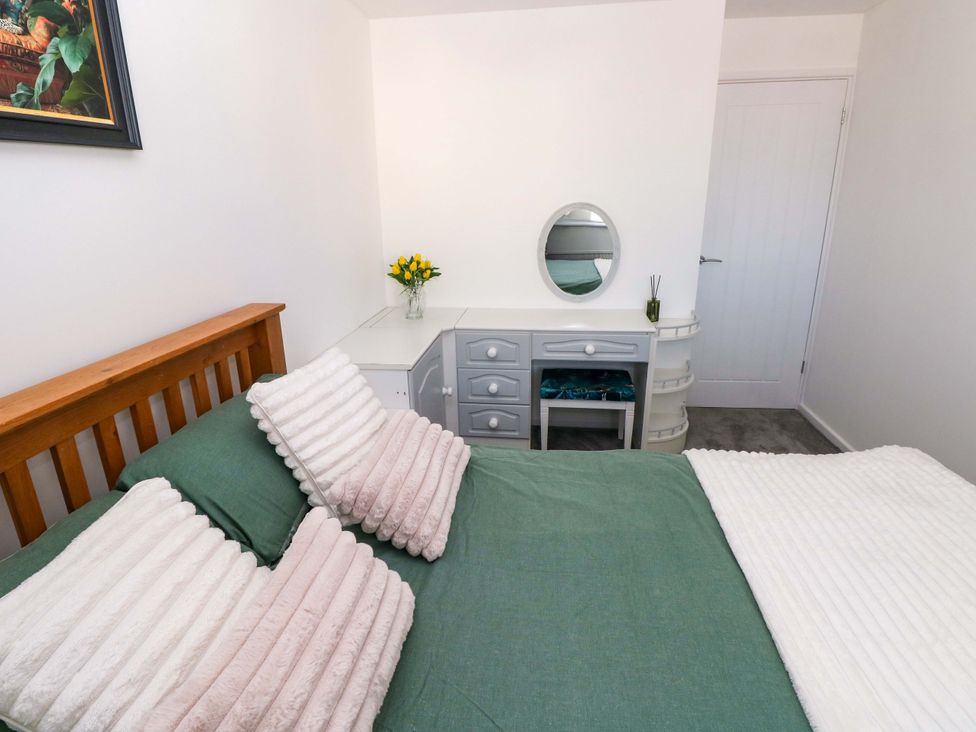 A bedroom with a bed and dresser at The Gower Gateway in Gowerton near Swansea