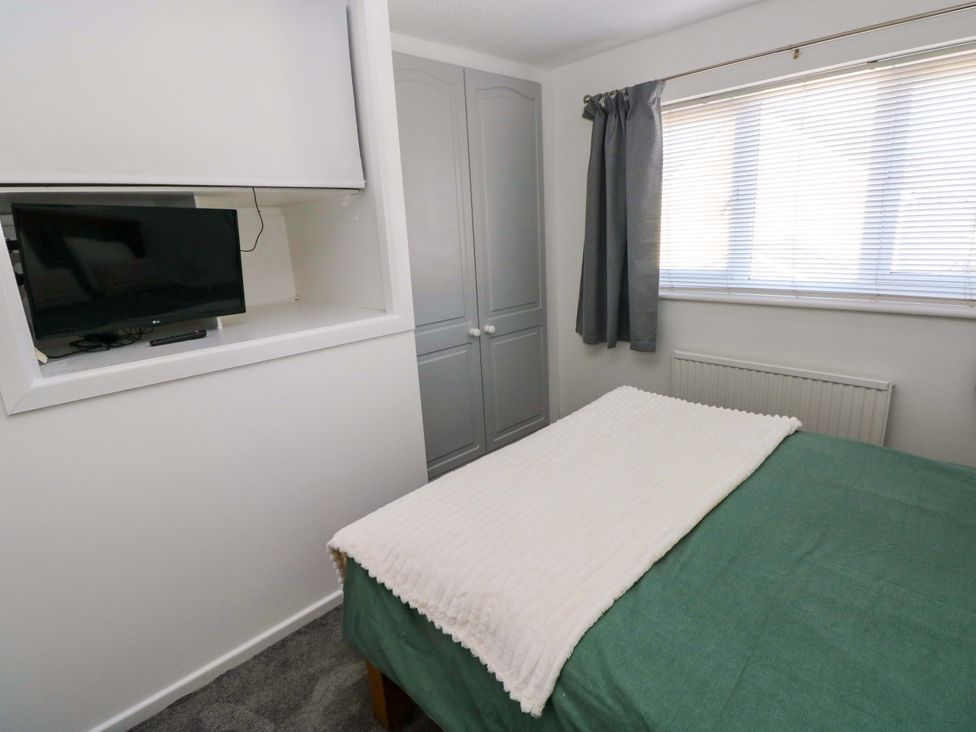A bedroom with a bed, television, and wardrobe at The Gower Gateway in Gowerton near Swansea