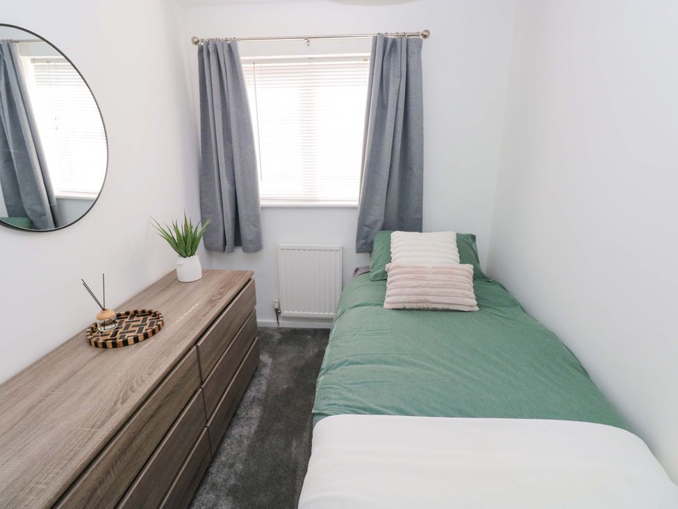 A bedroom with a bed and chest of drawers at The Gower Gateway in Gowerton near Swansea