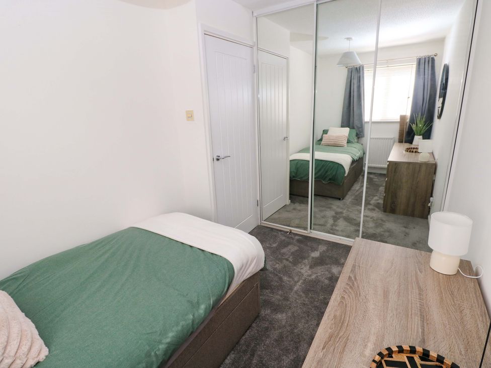 A bedroom with a bed, wardrobe, and desk at The Gower Gateway in Gowerton near Swansea
