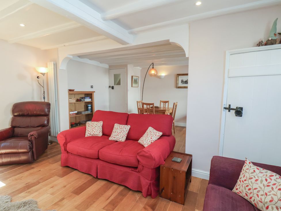 A living room with a sofa and armchair at Fleming Cottage