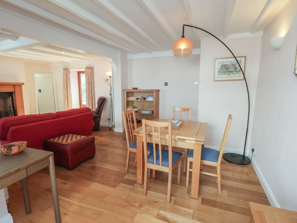 A living room with a sofa and dining area at Fleming Cottage