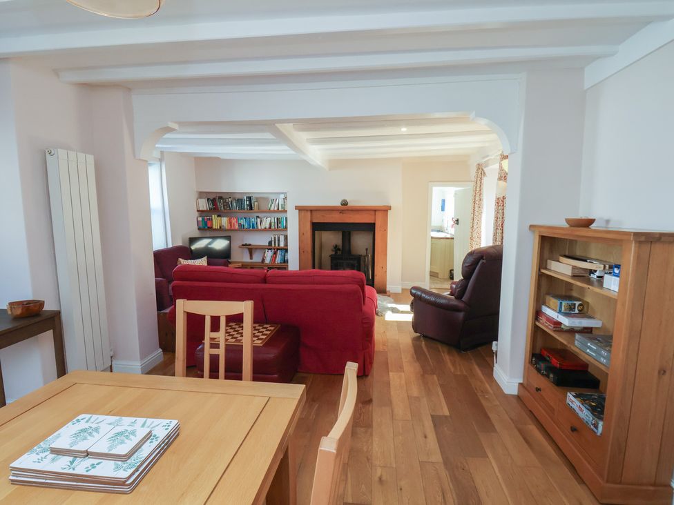 A living room with a fireplace and bookshelf at Fleming Cottage