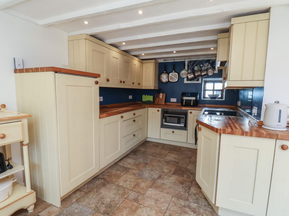 A kitchen with cabinets and appliances at Fleming Cottage