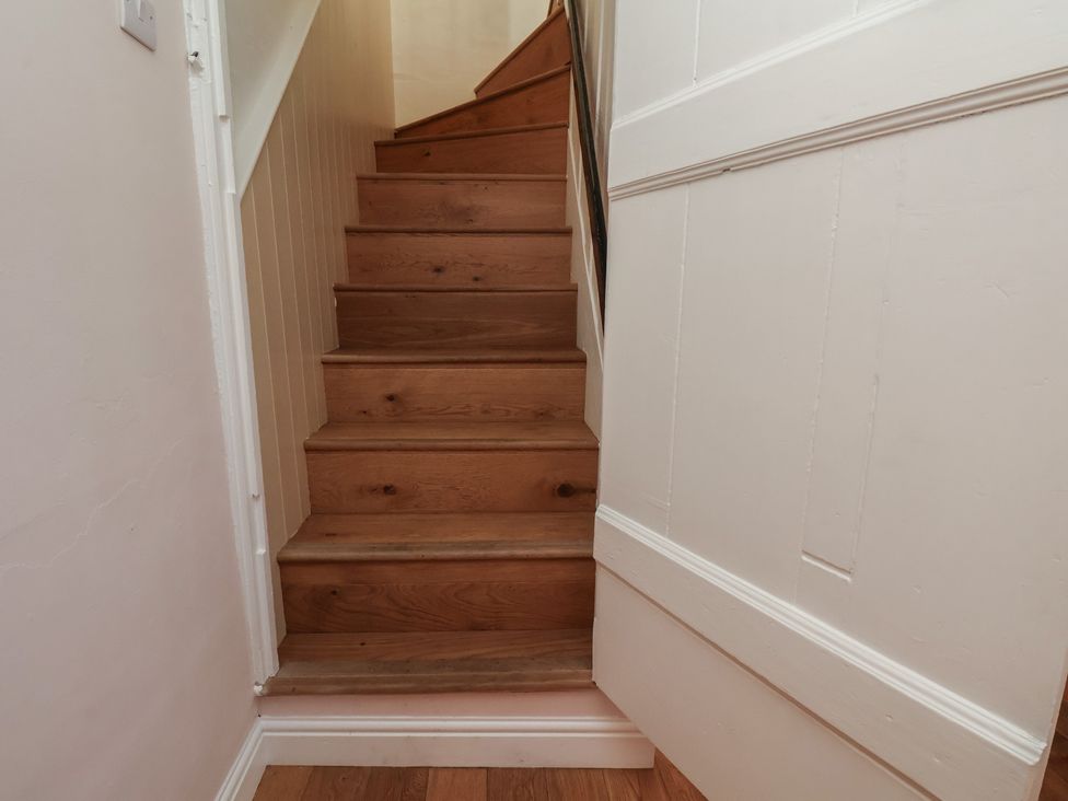 A staircase with wooden steps and a wall at Fleming Cottage