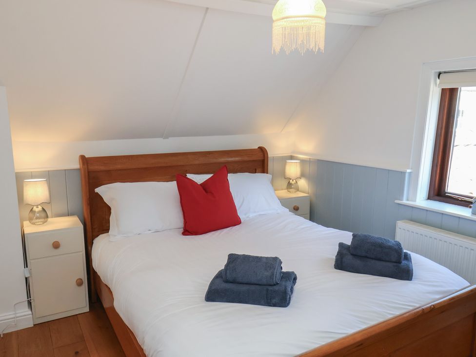 A bedroom with a double bed and bedside lamps at Fleming Cottage