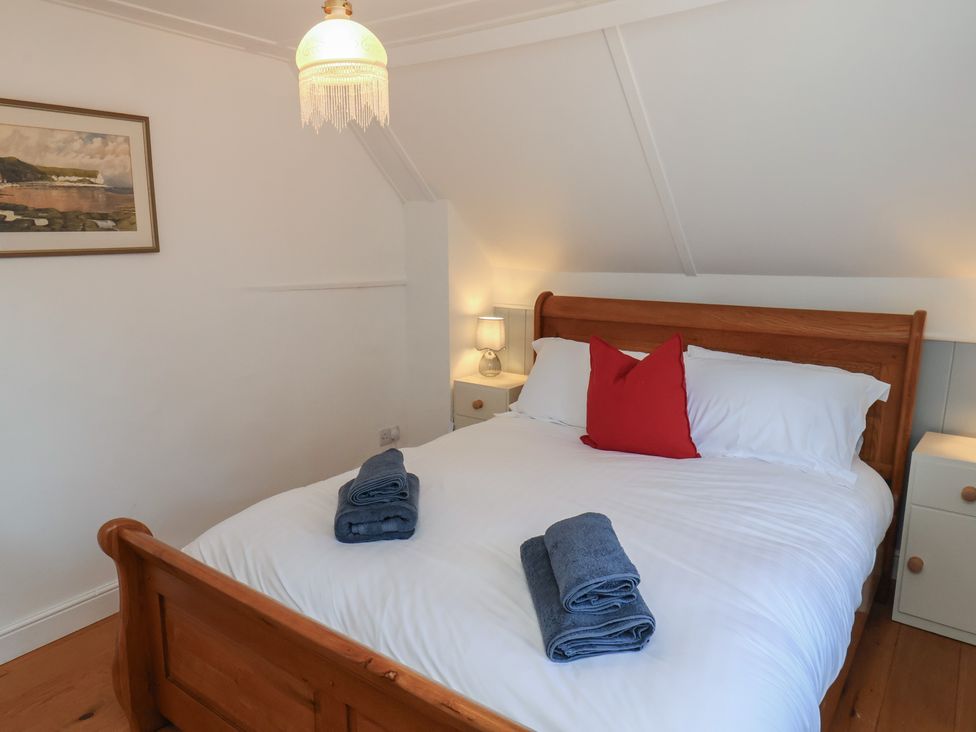 A bedroom with a double bed and bedside lamps at Fleming Cottage 