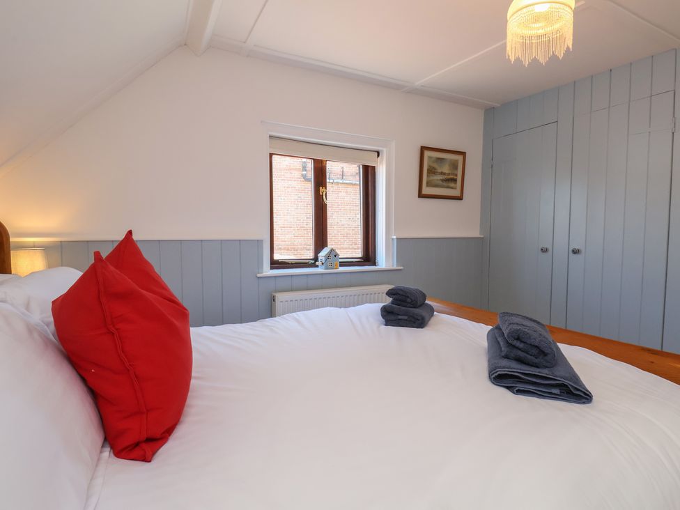 A bedroom with a bed and towels at Fleming Cottage in 