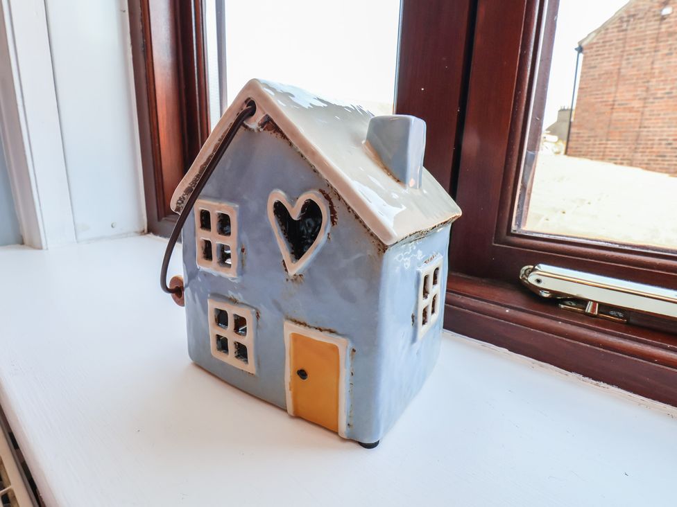 A ceramic house figurine on a windowsill at Fleming Cottage