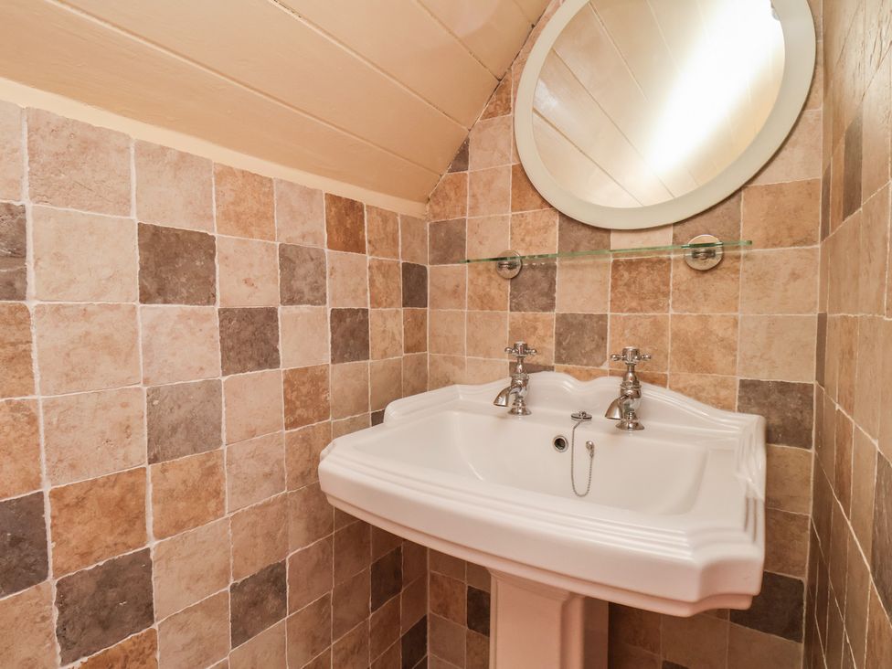 A bathroom with a sink and a mirror at Fleming Cottage 