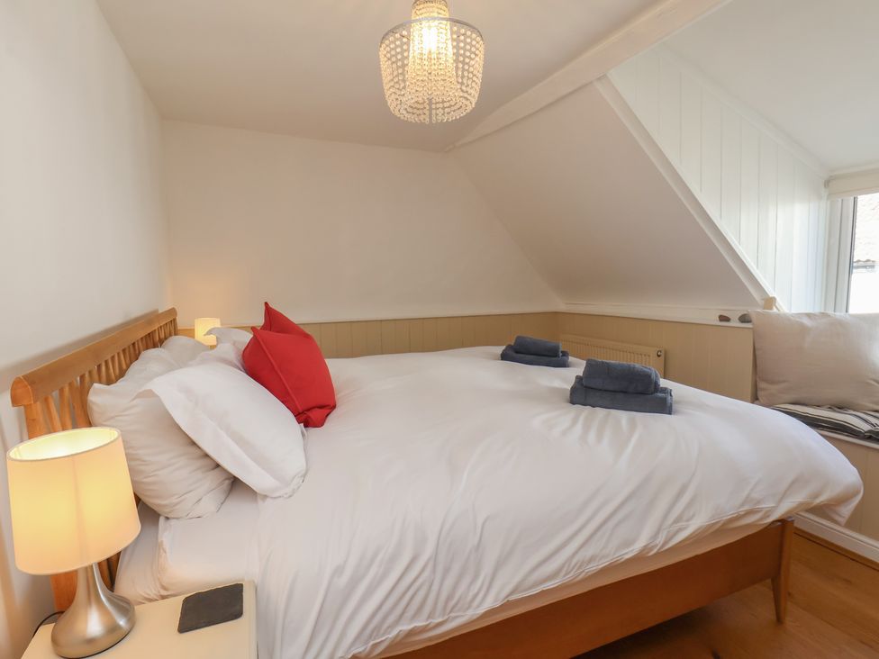 A bedroom with a bed and towels on top at Fleming Cottage