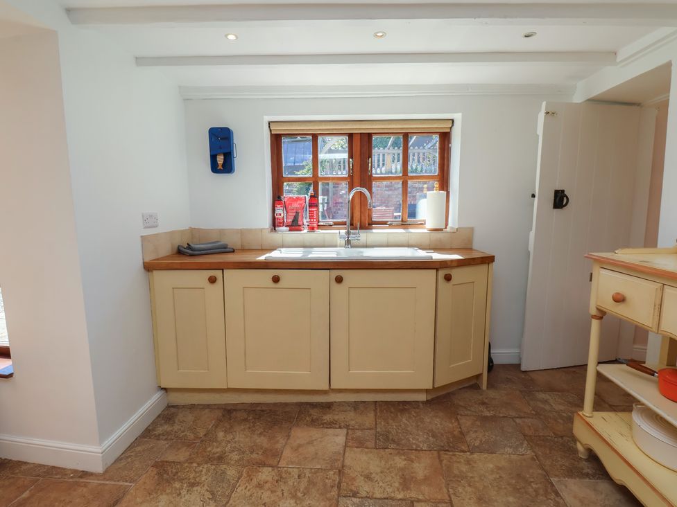 A kitchen with cabinets and a sink at Fleming Cottage
