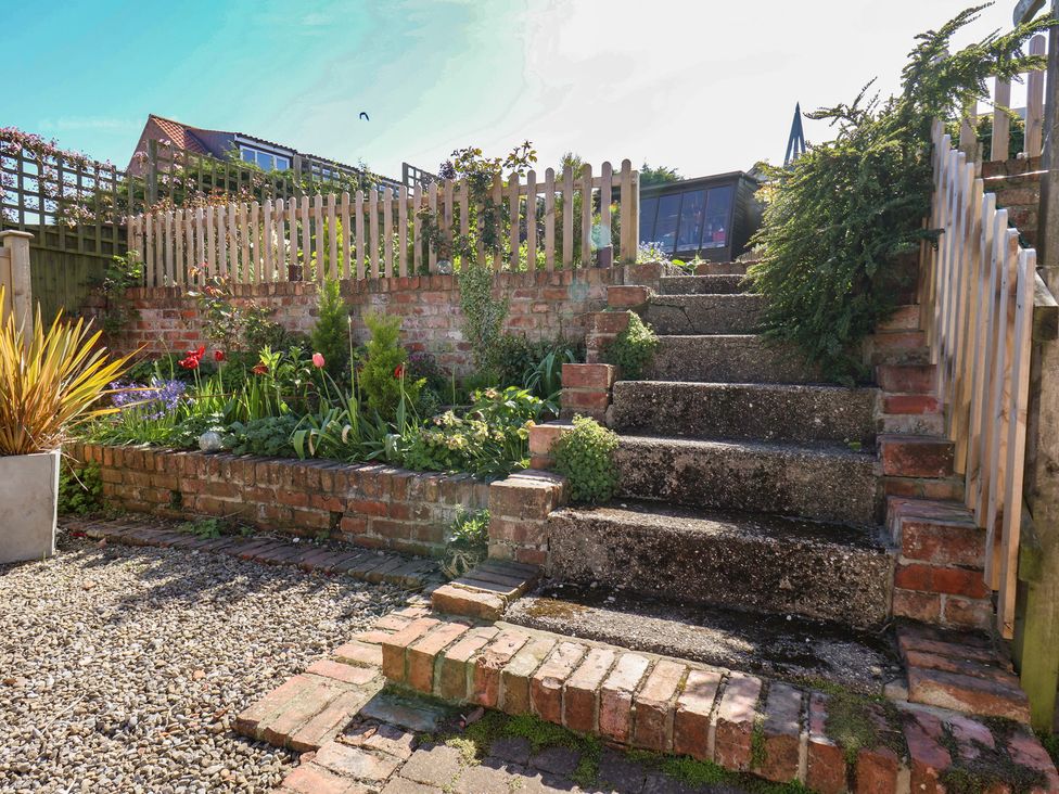 A garden with steps leading to a flower bed at Fleming Cottage