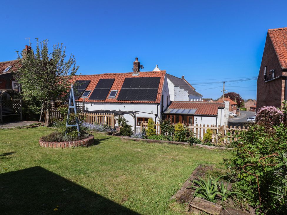 A garden with a fence and solar panels at Fleming Cottage in 