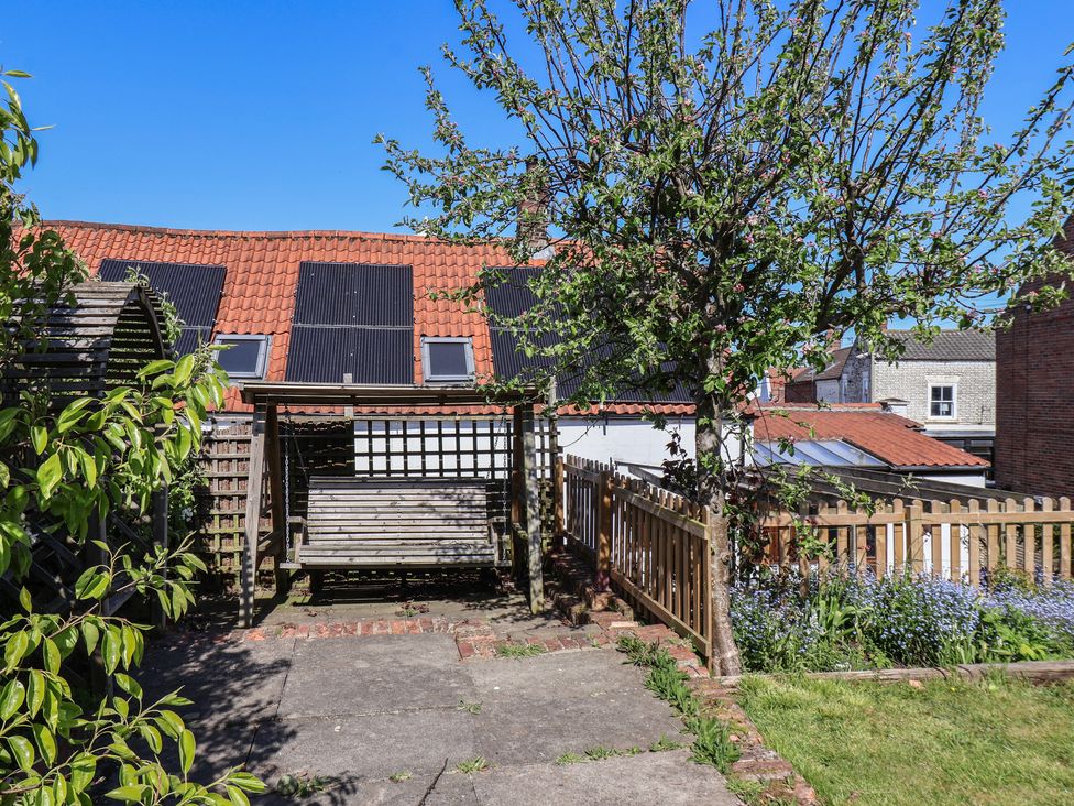 A garden with a swing and a tree at Fleming Cottage in 