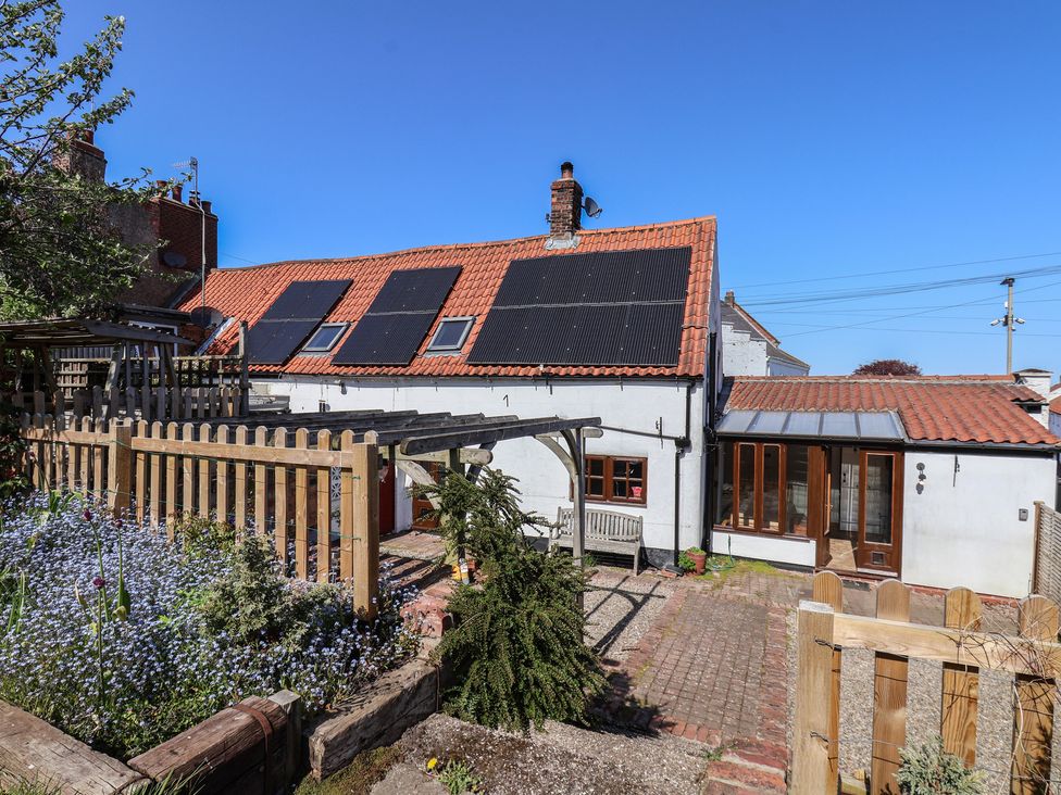 An outdoor area with a house and garden features at Fleming Cottage