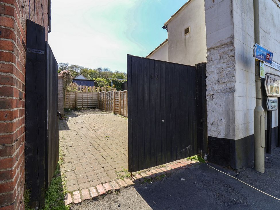 An outdoor area with a gate and paved stones at Fleming Cottage