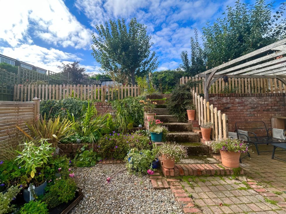 A garden with steps and flower pots at Fleming Cottage in Hunmanby
