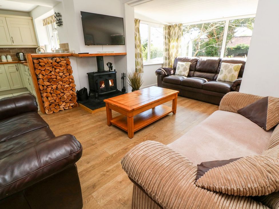 A living room with a fireplace and sofas at Tinners Way in Helston
