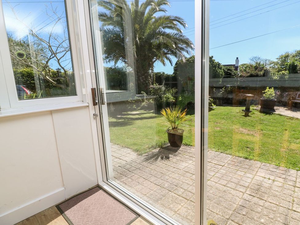 A conservatory with a view of a garden at Tinners Way in Helston
