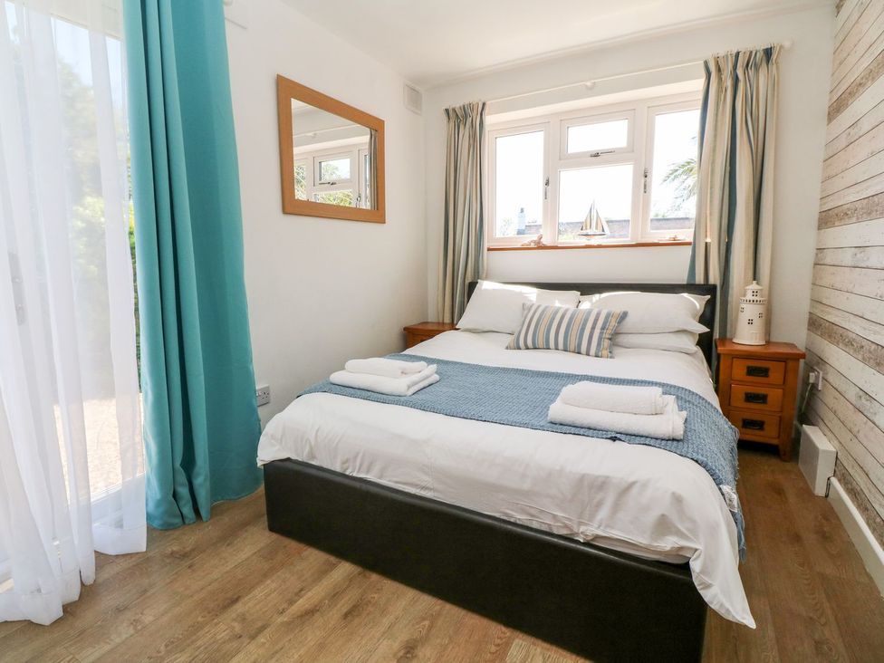 A bedroom with a bed and bedside table at Tinners Way in Helston