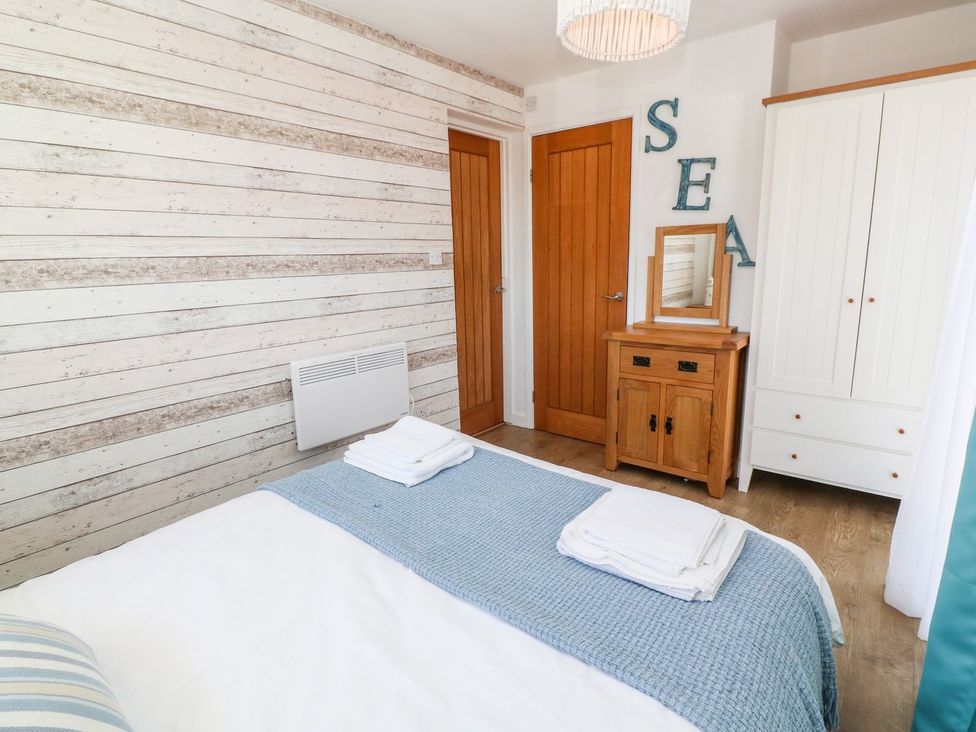 A bedroom with a bed and wardrobe at Tinners Way in Helston