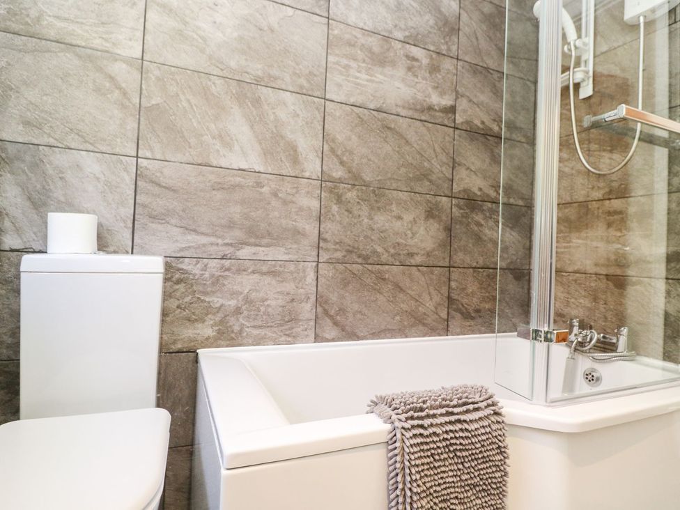 A bathroom with a bathtub and toilet at Tinners Way in Helston